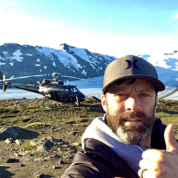 Julien Gfeller next to a helicopter