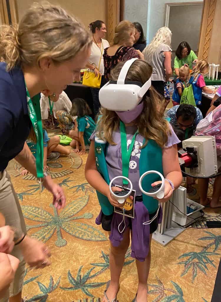 An instructor speaks to a girl scout wearing a VR headset
