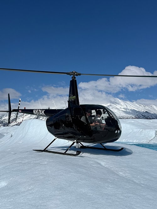 A helicopter sits on a glacier